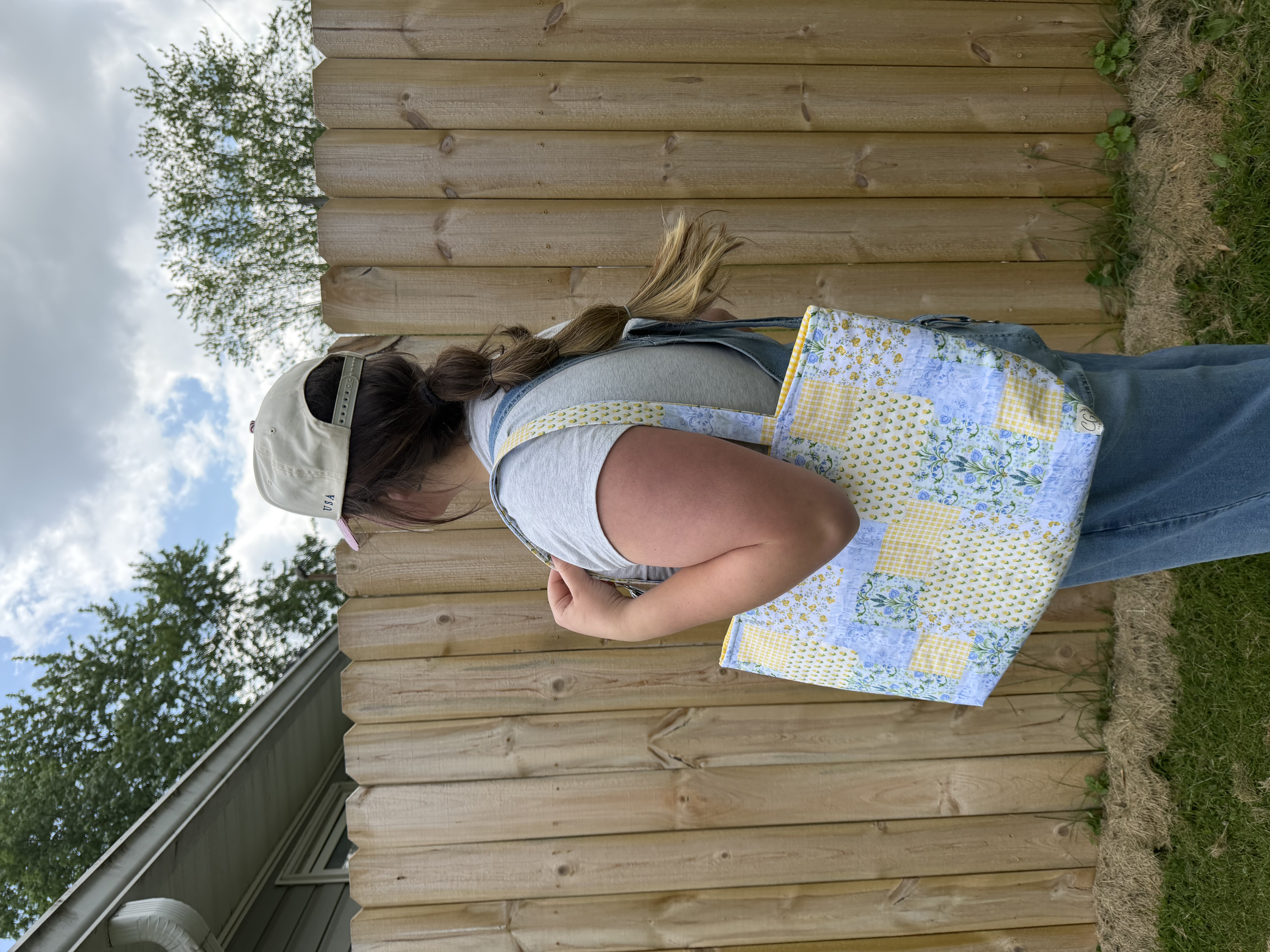 Blue and yellow quilt tote bag worn outdoors