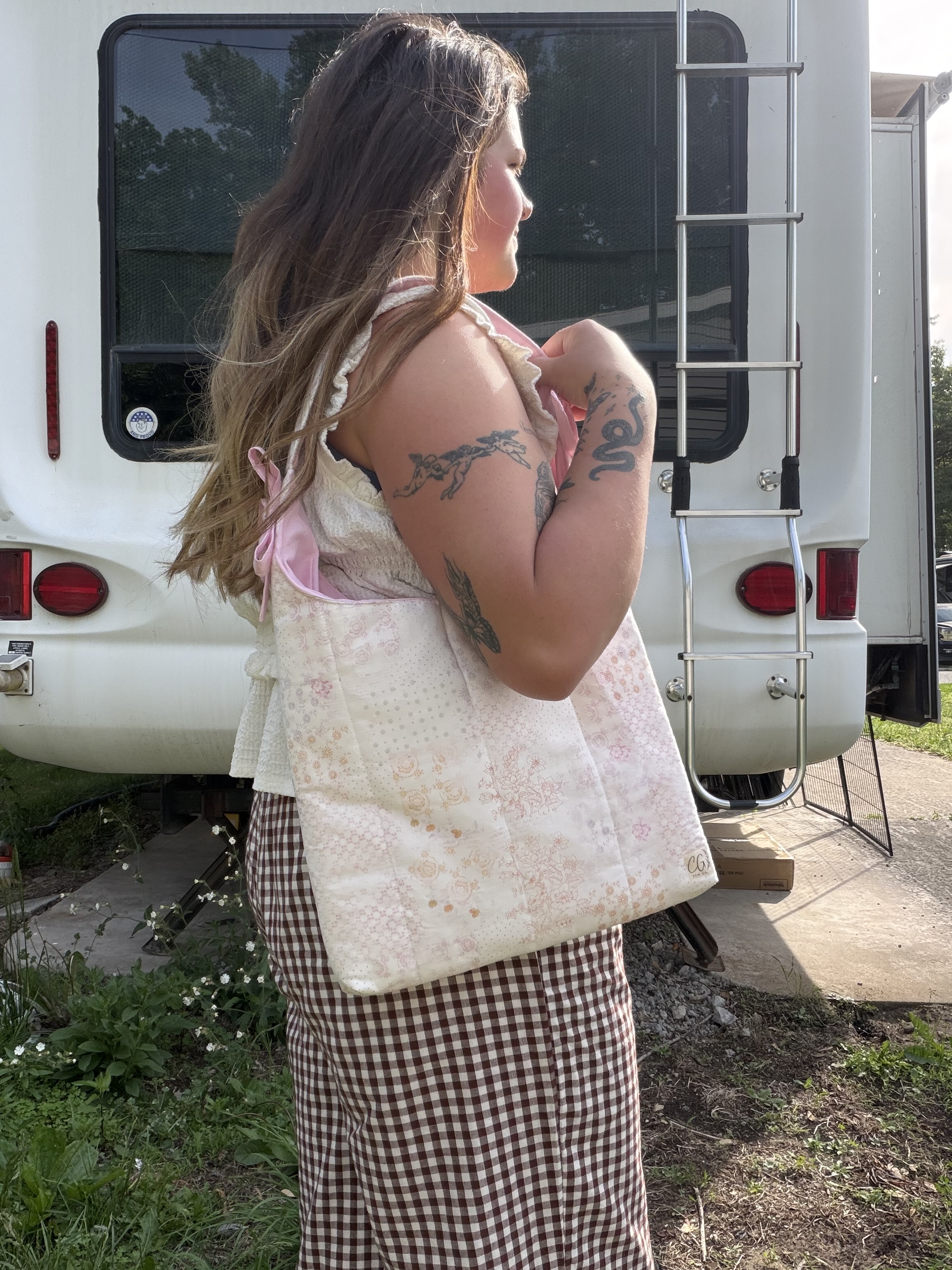 Model wearing blush patchwork quilt tote with shoulder tie